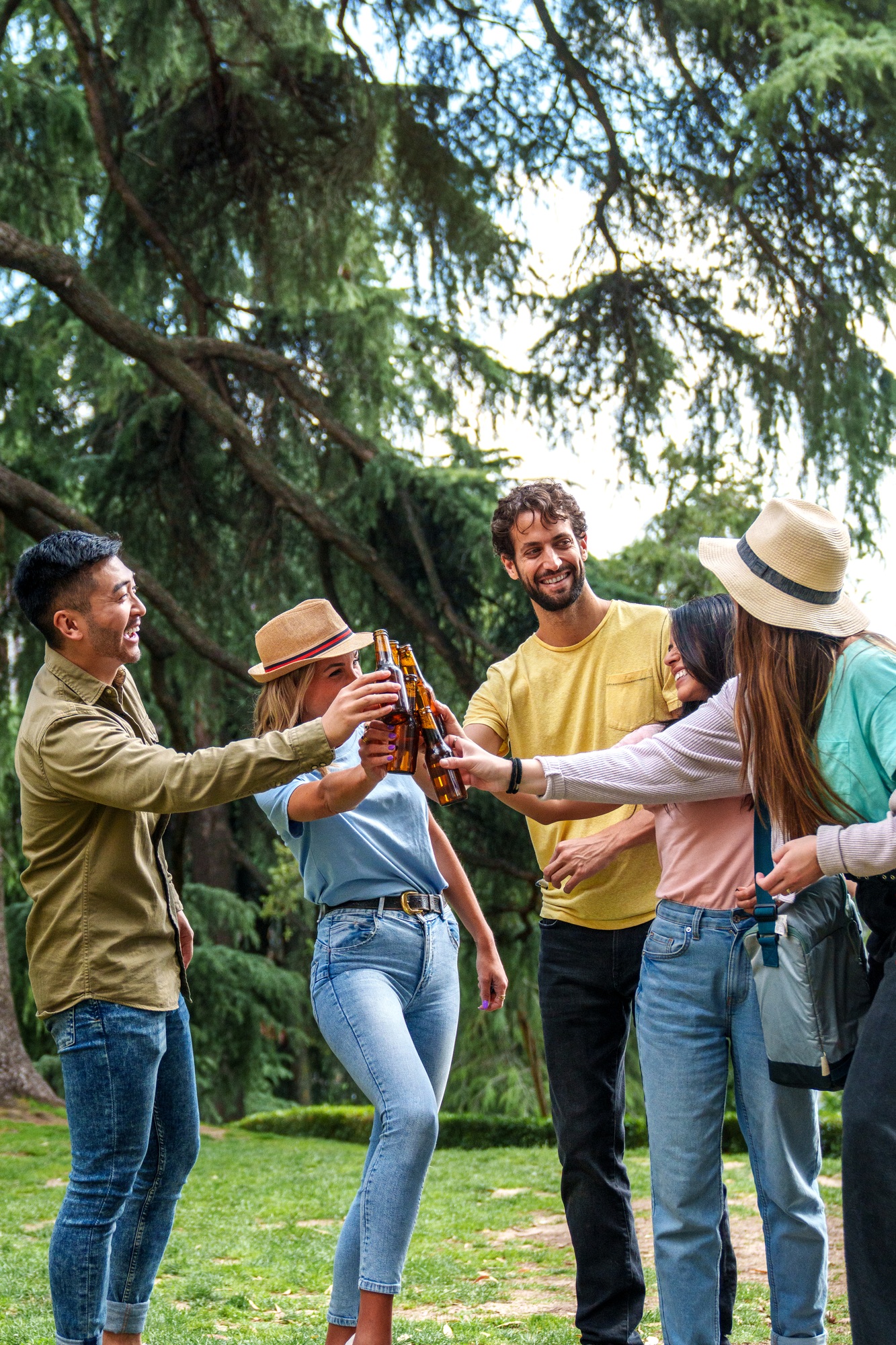 Friends Toasting with Beer Bottles at a Sunny Park Gathering